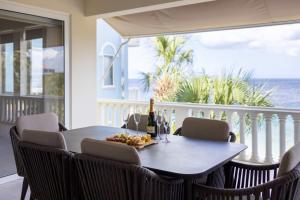 a table with a bottle of wine and food on a balcony at Blue Emerald at Blue Bay Beach & Golf Resort in Sint Michiel