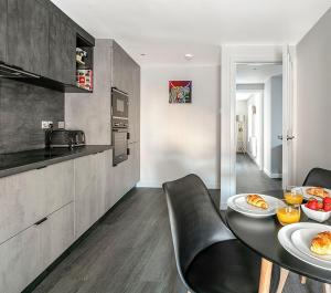 a kitchen with a table with plates of food on it at Castle Street Apartments - Luxury Ettrick Apartment in Rothesay