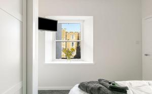 a bedroom with a window and a stuffed animal on a bed at Castle Street Apartments - Luxury Ettrick Apartment in Rothesay +17 photos