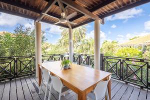an outdoor deck with a wooden table and chairs at The Village at Blue Bay Golf & Beach Resort in Sint Michiel