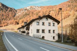 a white building on the side of a road at Residenza da Ennio in Tschierv
