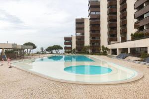 una piscina vuota di fronte a un edificio di Oceanfront Lux Condo Sleeps 9 a Cascais