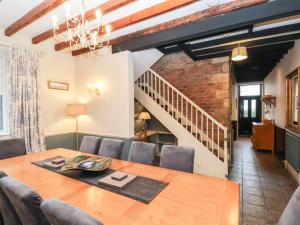 a dining room with a table and a staircase at The Farmhouse in Whitby