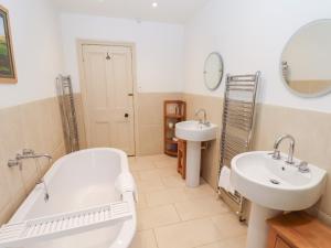 a bathroom with a tub and two sinks and a bath tub at The Farmhouse in Whitby +49 photos