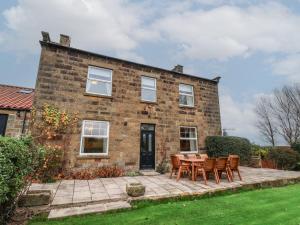 a brick house with a table and chairs in front of it at The Farmhouse in Whitby