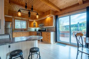 una cucina con armadi in legno e una grande finestra di Au Chic Chalet des Chutes Chic Cottage a Sainte-Melanie