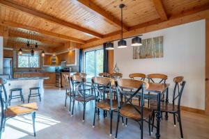 una cucina e una sala da pranzo con tavolo e sedie di Au Chic Chalet des Chutes Chic Cottage a Sainte-Melanie Altre 74 foto
