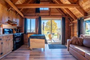 a living room with a couch and a table at Au Chic Chalet des Chutes Chic Rustique in Sainte-Melanie +56 photos