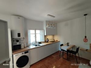 a white kitchen with a sink and a table at villa molinos in Otura