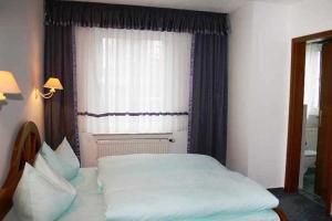 a bedroom with a large bed in front of a window at Hotel Rodewisch in Rodewisch