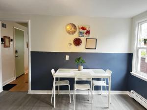 een eetkamer met een witte tafel en stoelen bij Stylish 1-BDRM Prime Location, Unit 2 in Halifax