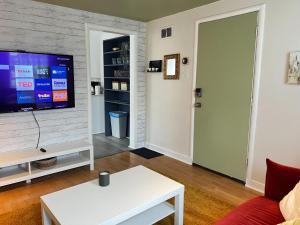 een woonkamer met een bank en een tv bij Stylish 1-BDRM Prime Location, Unit 2 in Halifax +6 foto's