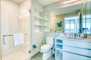 Un baño con inodoro y ducha de cristal. en Stunning Apt with City Views, en Boston