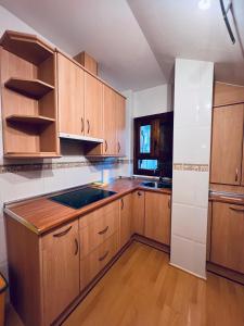 a kitchen with wooden cabinets and a counter top at Apartamento Espata VII in Villanúa