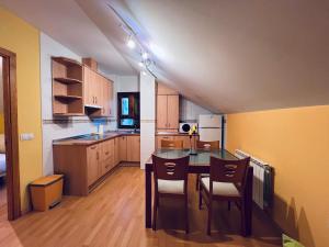 a kitchen with a table and chairs in a room at Apartamento Espata VII in Villanúa