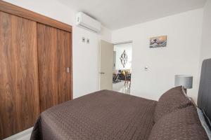 a bedroom with a bed and a wooden cabinet at Cozy 2-Bedroom Retreat with Pool Access in Manzanillo +27 photos