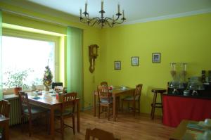 a dining room with green walls and wooden tables and chairs at Atlantis Landpension Steinhude in Wunstorf