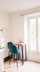 Un escritorio y una silla en una habitación con ventana. en Studio lumineux au charme parisien, en Vincennes