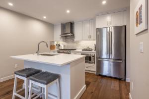 a kitchen with a stainless steel refrigerator and wooden floors at New 1Bd Luxe King Suite with Superb Mtn View in Canmore
