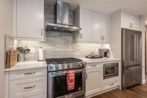 a kitchen with white cabinets and a stove top oven at New 1Bd Luxe King Suite with Superb Mtn View in Canmore