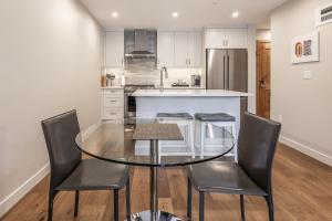 a kitchen with a glass table and two chairs at New 1Bd Luxe King Suite with Superb Mtn View in Canmore