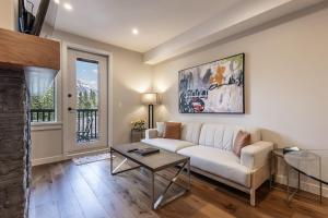 a living room with a white couch and a table at New 1Bd Luxe King Suite with Superb Mtn View in Canmore