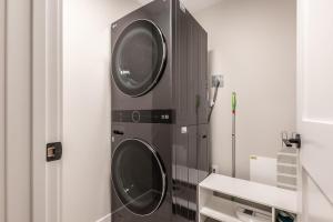 a washing machine in a bathroom with a sink at New 1Bd Luxe King Suite with Superb Mtn View in Canmore