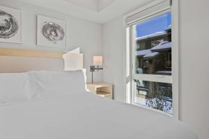 a white bedroom with a bed and a window at Outdoor heated pool and hot tub Stunning 3Bd sanctuary in Dead Man's Flats +43 photos