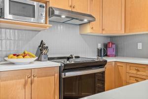 a kitchen with a sink and a bowl of fruit at Freshly Remodeled - 2 King Beds- Breathtaking Views in Canmore