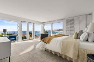 une chambre avec un grand lit et de grandes fenêtres dans l'établissement Sea Serenity Coastline Views and Pool, à San Diego 46 autres photos