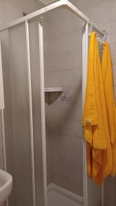 ein Bad mit einer Dusche und einem gelben Handtuch in der Unterkunft Appartamento 93 di andrea sonzogni in Castelleone + 29 Fotos