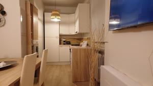 eine Küche mit weißen Schränken und einem Tisch und Stühlen in der Unterkunft Appartamento 93 di andrea sonzogni in Castelleone