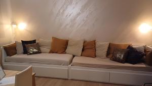 ein Sofa mit vielen Kissen auf einem Zimmer in der Unterkunft Appartamento 93 di andrea sonzogni in Castelleone