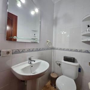 a white bathroom with a toilet and a sink at Casa Criso Puerto del Rosario in Puerto del Rosario +19 photos
