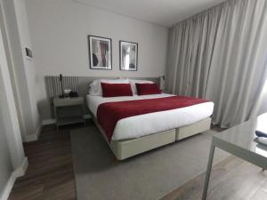 a bedroom with a large bed with red pillows at Guemes Hotel & Spa in Salta