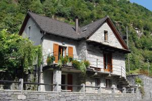 ein Haus auf einer Steinmauer in der Unterkunft Casa Fontanella in Brione