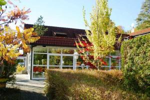 a building with a large glass door in a yard at Hotel Rodewisch in Rodewisch