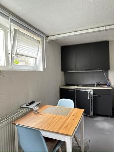 una pequeña cocina con mesa de madera y sillas en Ferienwohnung Nähe Stadtmitte, en Friedrichshafen