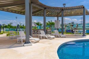 a pool at a resort with chairs and a table at Your Perfect Getaway in Acapulco in La Sabana