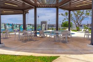 a patio with tables and chairs and a pool at Your Perfect Getaway in Acapulco in La Sabana