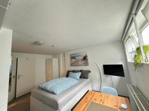 a small bedroom with a bed and a table at Ferienwohnung Nähe Stadtmitte in Friedrichshafen