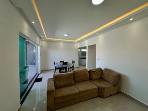 a living room with a couch and a table at casa a 600 metros da praia in Peruíbe