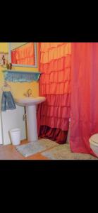 a bathroom with a sink and a shower curtain at Coral Cove Cottage in Negril +25 photos