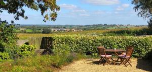 a table and chairs with a view of a field at The View Cottage - Tennis Court - Nr Frome, Longleat in Frome
