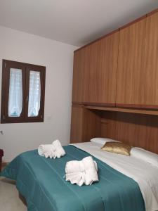 a bedroom with two towels on a bed at La Rugiada-con giardino privato in Alcamo