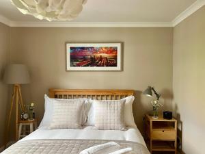 a bedroom with a bed and a painting on the wall at Leaze Garden Cottage - Frome in Frome