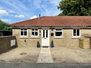 a small brick house with a white door at Leaze Garden Cottage - Frome in Frome