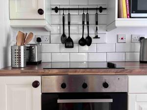 eine Küche mit Herd und Geschirr an der Wand in der Unterkunft Cosy Weavers Cottage - Heart of Frome in Frome + 8 Fotos