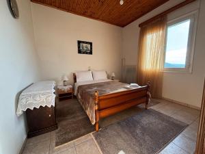 a bedroom with a bed and a large window at Georgaras Accommodation in Platanoússa
