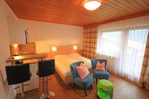 1 Schlafzimmer mit einem Bett, 2 Stühlen und einem Schreibtisch in der Unterkunft Haus Astrid-Christoph in Finkenberg